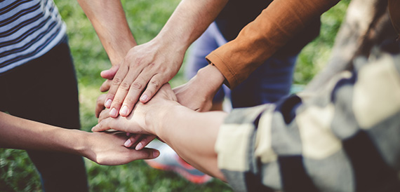 Diverse group of people stacking hands