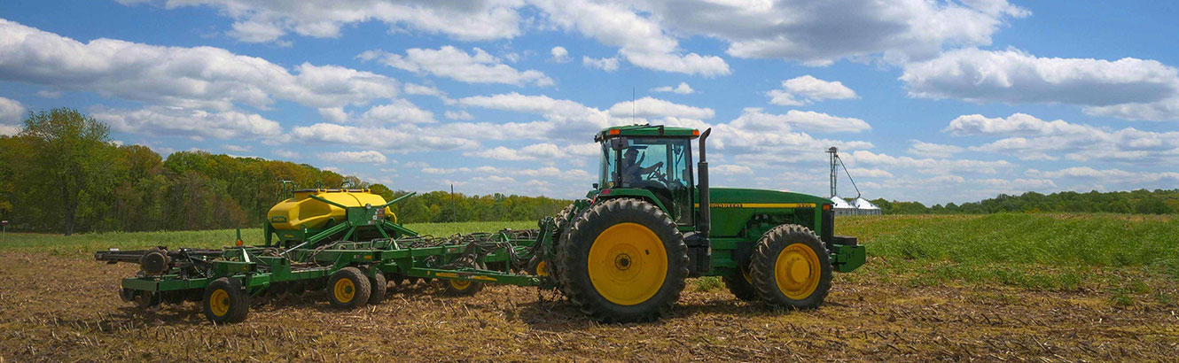 Framer driving a tractor plowing a field